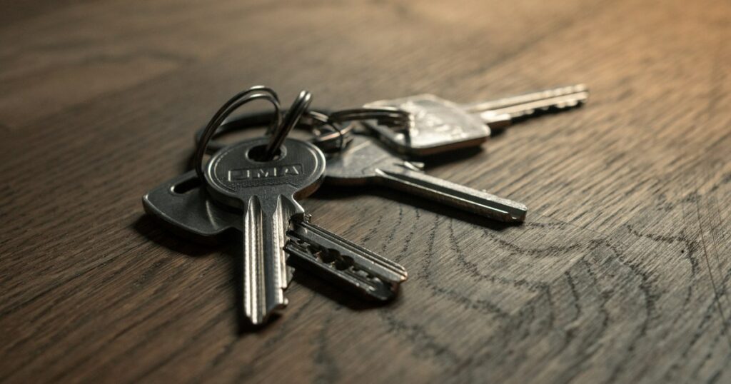 A set of house keys on a wooden table, representing selling a home privately in Ontario